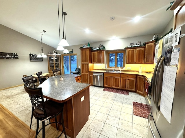 kitchen featuring pendant lighting, sink, a kitchen breakfast bar, stainless steel appliances, and a center island