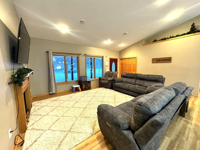 living room featuring lofted ceiling and light hardwood / wood-style flooring