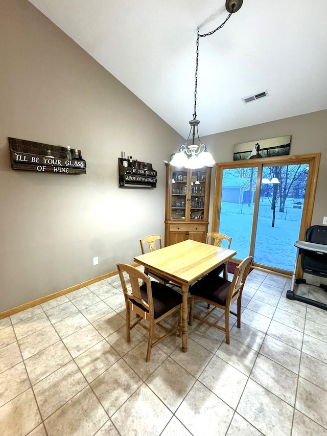 dining area with tile patterned flooring and vaulted ceiling