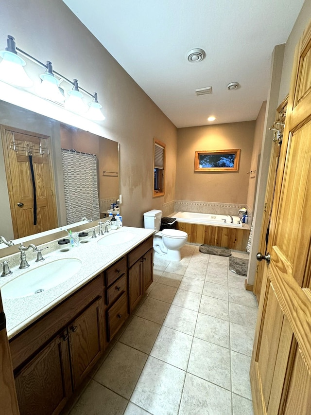 bathroom with vanity, a bath, tile patterned floors, and toilet