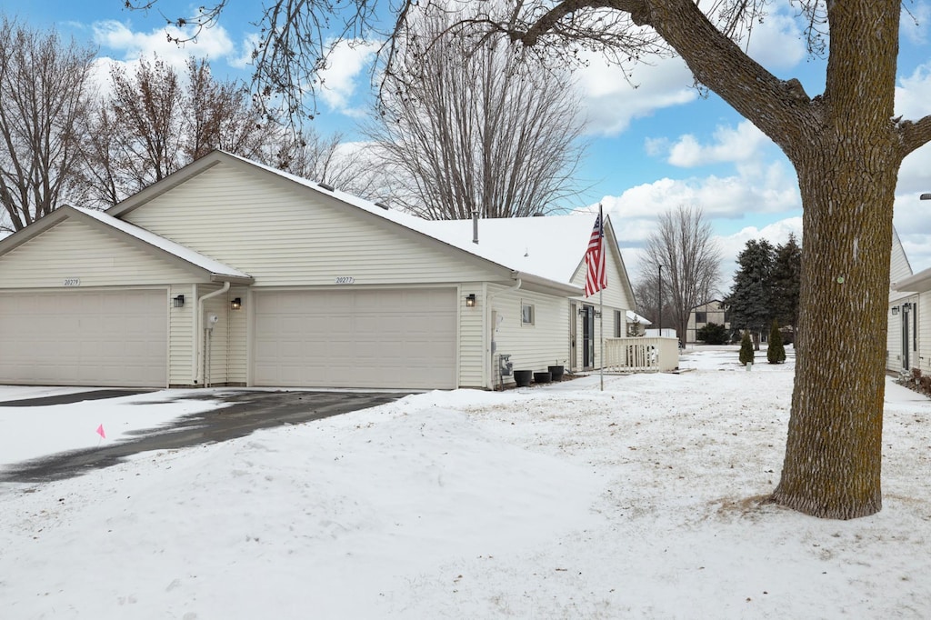 snow covered property with a garage