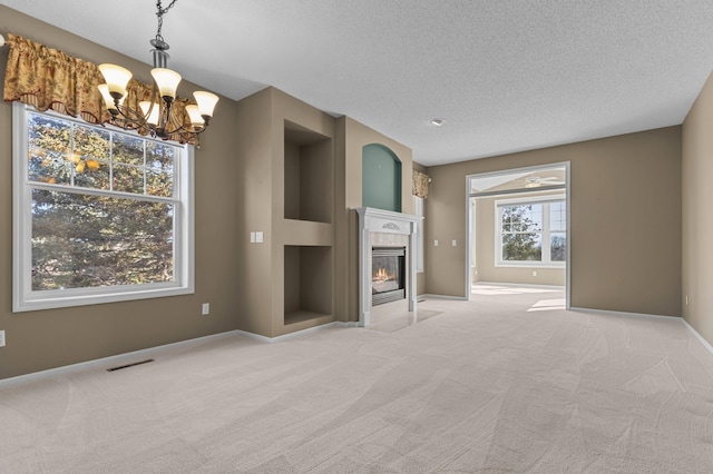 unfurnished living room with a textured ceiling, baseboards, carpet flooring, and a tile fireplace