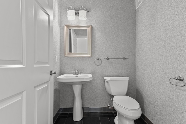 half bathroom featuring visible vents, a sink, tile patterned flooring, and toilet