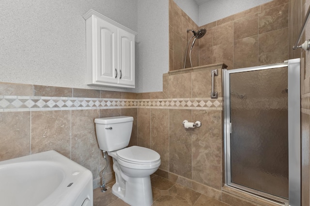 bathroom with a stall shower, a bathing tub, tile patterned flooring, and toilet