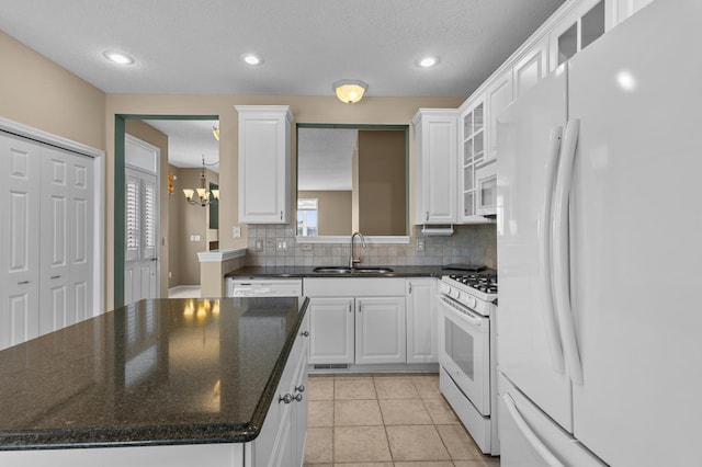 kitchen with light tile patterned floors, white appliances, a sink, a center island, and decorative backsplash