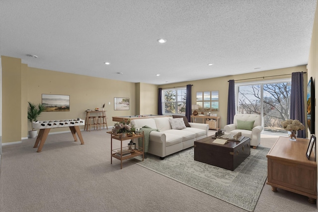 carpeted living area featuring recessed lighting, a healthy amount of sunlight, a textured ceiling, and baseboards