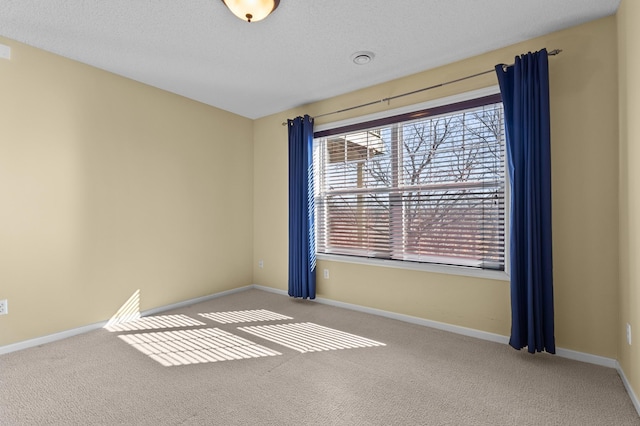 unfurnished room with carpet flooring, a textured ceiling, and baseboards