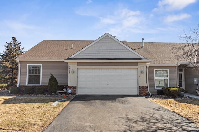 view of front facade featuring a garage, brick siding, a shingled roof, and aphalt driveway