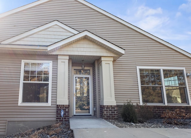 view of exterior entry featuring brick siding