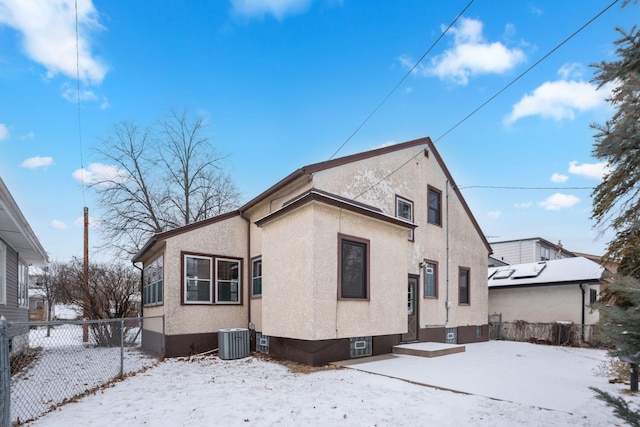 snow covered property with central AC