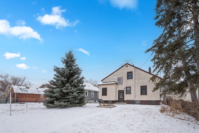 view of snow covered back of property