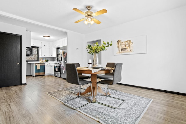 dining space featuring ceiling fan and light wood-type flooring