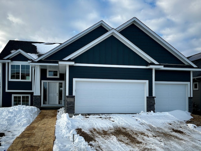 craftsman-style house featuring a garage, stone siding, and board and batten siding