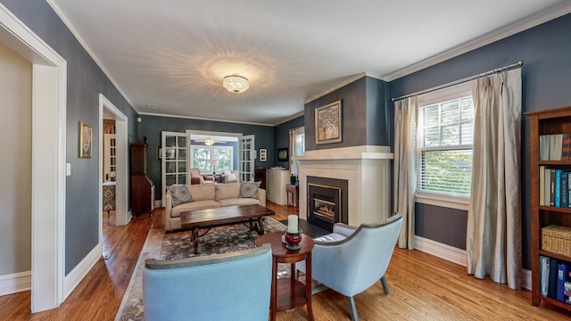 living room with hardwood / wood-style flooring, ornamental molding, and a wealth of natural light