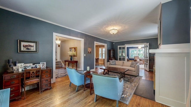 living room featuring crown molding and light hardwood / wood-style flooring