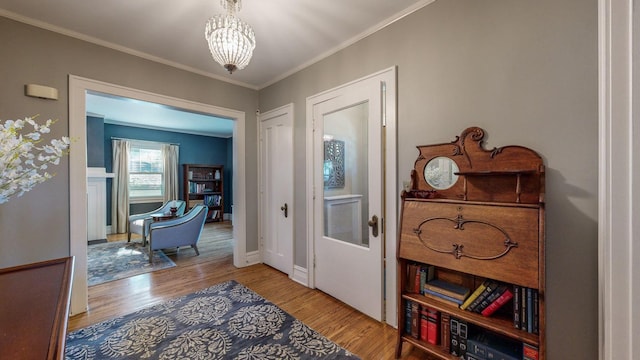 entrance foyer featuring an inviting chandelier, crown molding, and hardwood / wood-style floors