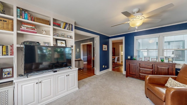 living room with light carpet, ornamental molding, and ceiling fan