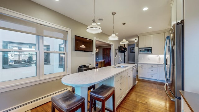 kitchen featuring white cabinetry, sink, stainless steel appliances, and baseboard heating