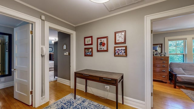 hallway with ornamental molding and hardwood / wood-style floors