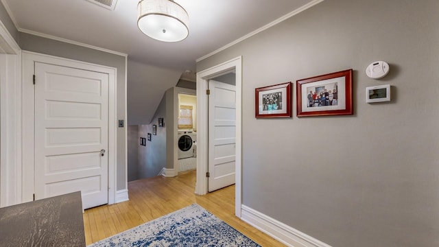 corridor featuring crown molding, washer / dryer, and light hardwood / wood-style floors