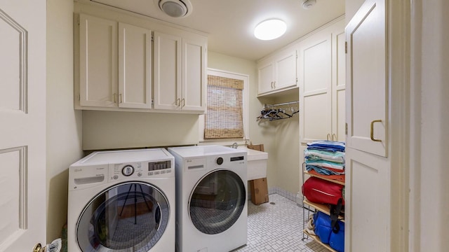 clothes washing area with light tile patterned flooring, cabinets, and separate washer and dryer