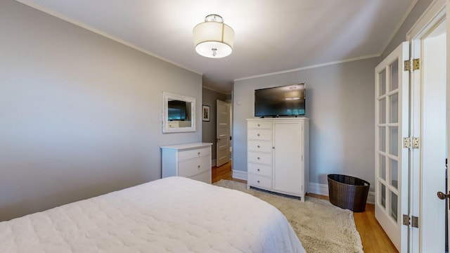 bedroom featuring french doors, ornamental molding, and light hardwood / wood-style floors