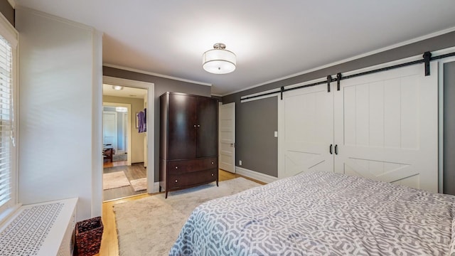 bedroom featuring ornamental molding and a barn door