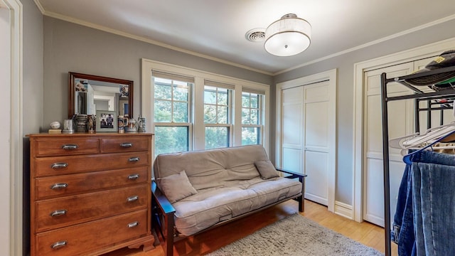 sitting room with crown molding and light hardwood / wood-style flooring