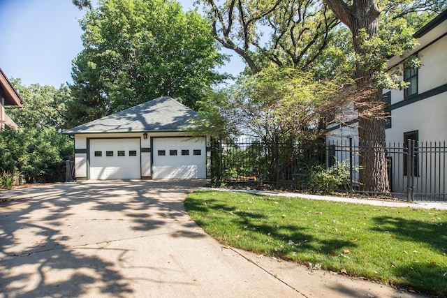 view of side of home featuring a garage, an outdoor structure, and a yard