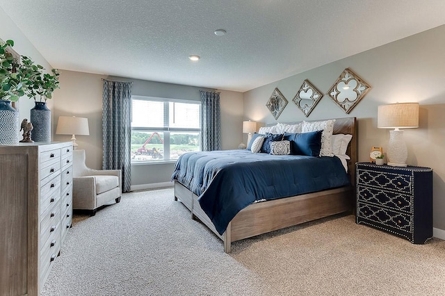 bedroom featuring light carpet and a textured ceiling