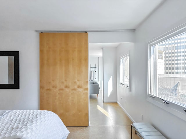 bedroom featuring radiator heating unit, multiple windows, concrete floors, and baseboards