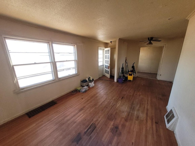 interior space featuring ceiling fan, dark wood-type flooring, and a textured ceiling