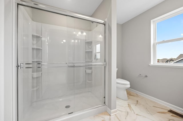 bathroom featuring toilet and a shower with door