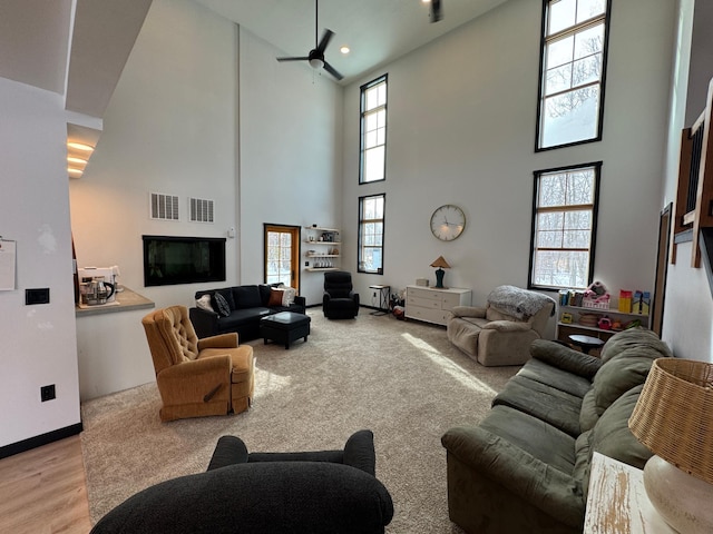 living room with ceiling fan and light hardwood / wood-style flooring