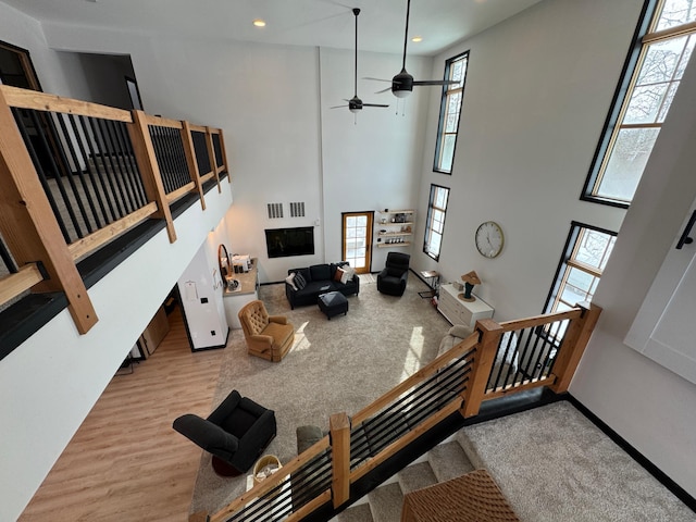 living room featuring a high ceiling, a healthy amount of sunlight, and light hardwood / wood-style floors