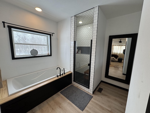 bathroom featuring wood-type flooring and shower with separate bathtub