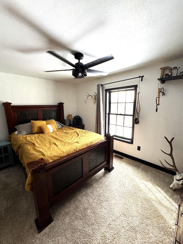 carpeted bedroom with ceiling fan and a textured ceiling