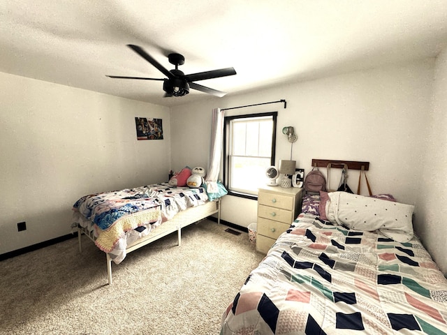 bedroom with ceiling fan, carpet floors, and a textured ceiling