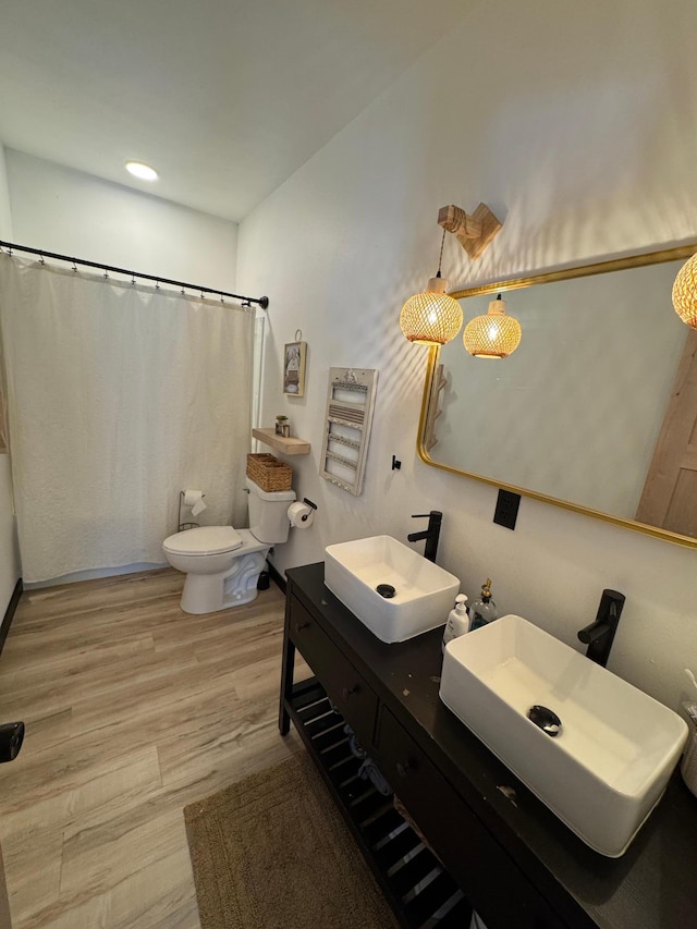 bathroom featuring vanity, toilet, curtained shower, and hardwood / wood-style floors