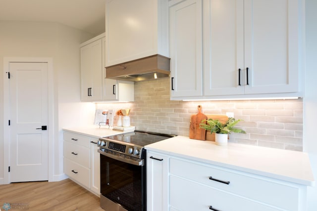 kitchen with backsplash, light wood-type flooring, white cabinetry, and stainless steel electric range