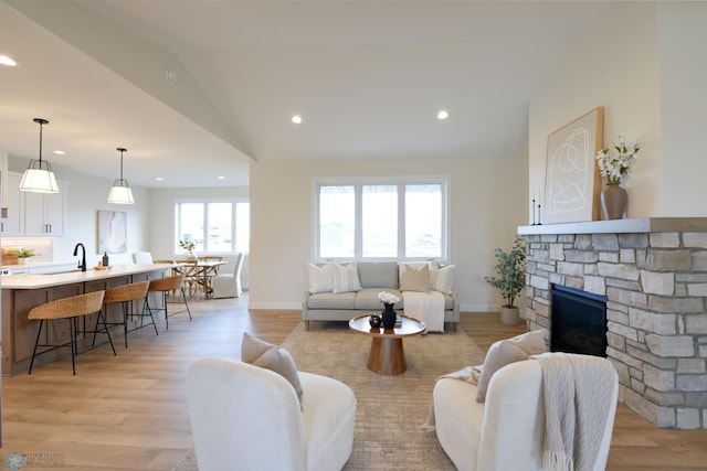 living room with recessed lighting, light wood-style floors, lofted ceiling, and baseboards