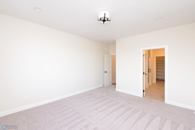 empty room with baseboards and light carpet