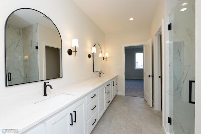 bathroom featuring recessed lighting, double vanity, a marble finish shower, and a sink