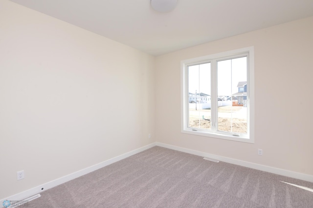 carpeted empty room with visible vents and baseboards