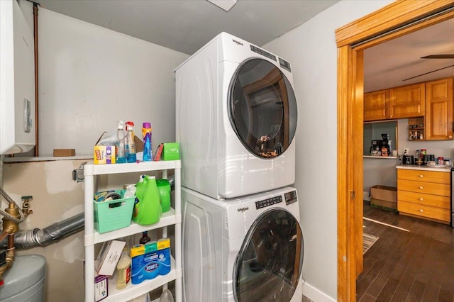 clothes washing area featuring stacked washing machine and dryer and dark wood-style floors