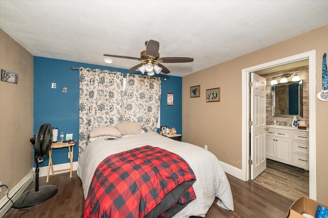 bedroom featuring dark wood-style flooring, ceiling fan, baseboards, a baseboard heating unit, and ensuite bathroom