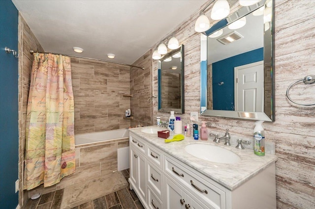 bathroom featuring double vanity and tiled shower / bath combo