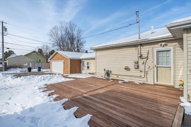 snow covered deck with a detached garage