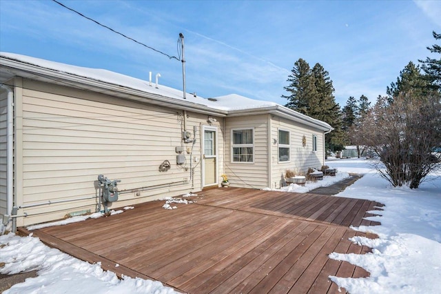 snow covered property with a deck