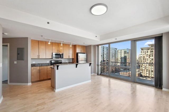 kitchen with electric panel, a breakfast bar, a center island, stainless steel appliances, and a city view